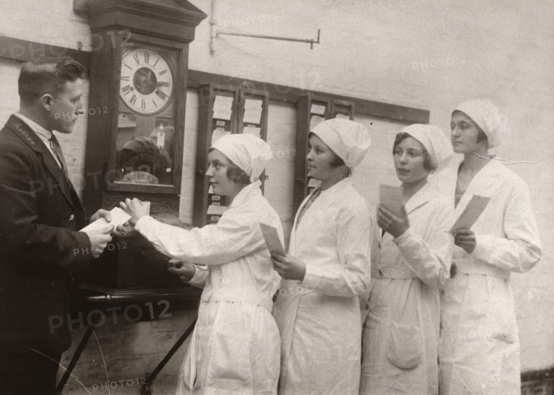 Girls queue at the Clocking-In machine, Rowntree factory, York, Yorkshire, 1933. Artist: Unknown