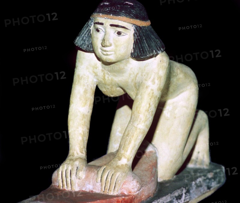 Painted figure of an Egyptian servant making bread. Artist: Unknown