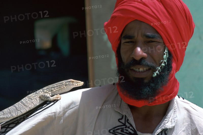 Keeper with a lizard in Tozeur zoo in Tunisia. Artist: Unknown