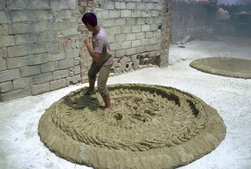 Treading clay for pottery in Tunisia. Artist: CM Dixon Artist: Unknown