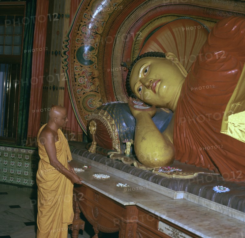 Buddhist priest before the image of a reclining Buddha. Artist: Unknown