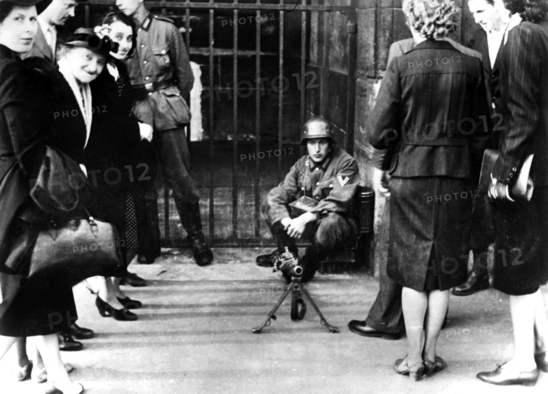 Civilians in front of a German guard post with a machine gun, Paris, June 1940. Artist: Unknown