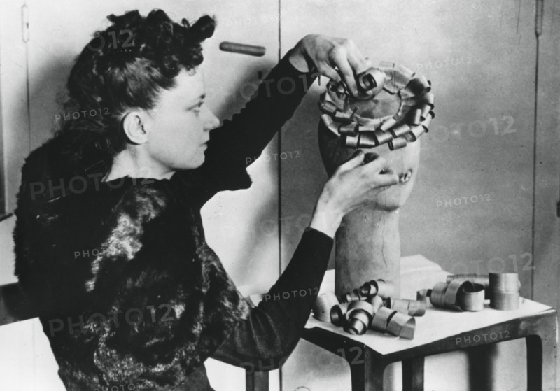 Woman making a hat from wood shavings, German-occupied France, April 1941. Artist: Unknown
