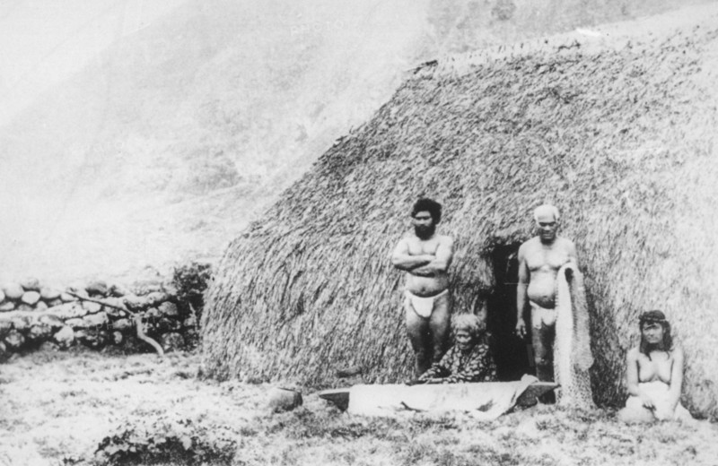 An old woman beating tapa in front of a pili grass house, Kalaupapa, Hawaii, 19th century. Artist: Unknown