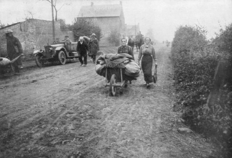 A British soldier helping a woman return to her village, France, 1918. Artist: Unknown