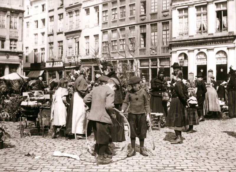 Boys with hoops at a market, Rotterdam, 1898.Artist: James Batkin