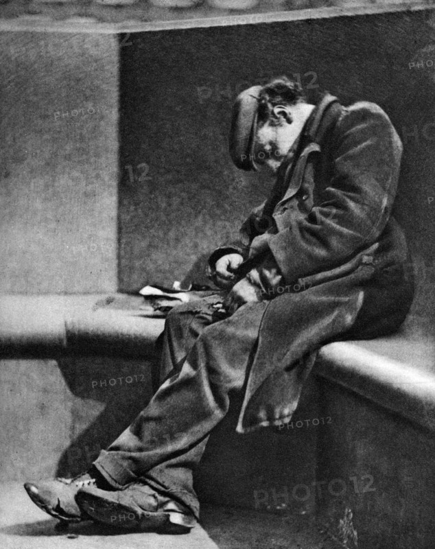 A man sleeping on Blackfriars Bridge, London, 1926-1927.Artist: Walter Benington