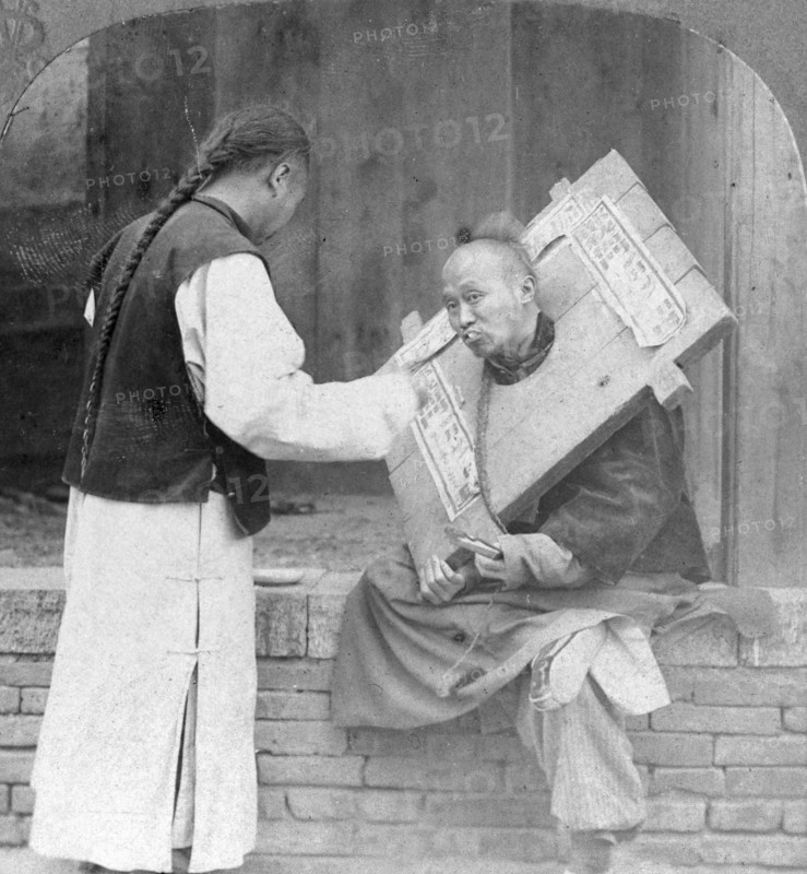 Feeding a prisoner wearing a cangue, China, 1902. Artist: CH Graves