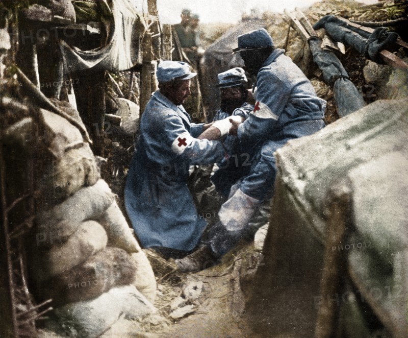 'First aid to a wounded man in one of the French trenches', 1915. Artist: Unknown.