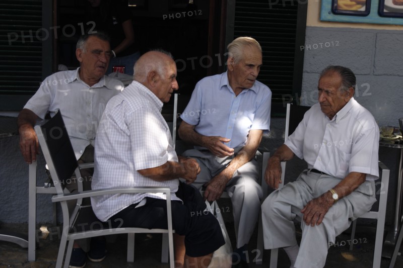 Group of men chatting at Pollensa Sunday market, Mallorca, Spain.