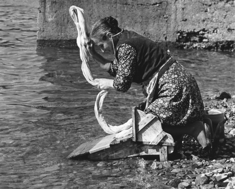 Woman washing clothes in a river, Portugal, 1973.