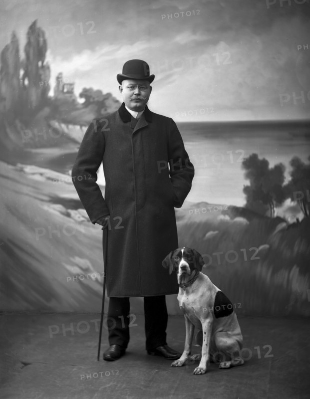 Elegant man wearing a black overcoat posing with his dog, Landskrona, Sweden, 1910. Artist: Unknown