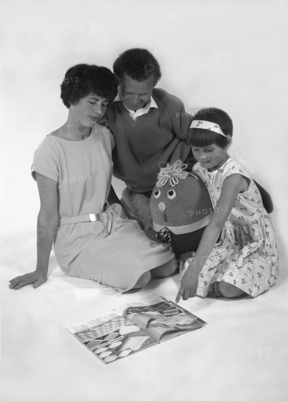 Family group looking at a magazine, 1963. Artist: Michael Walters