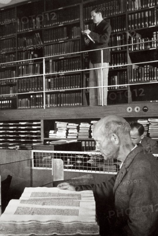 A labourer reads a book in a library, Germany, 1936. Artist: Unknown
