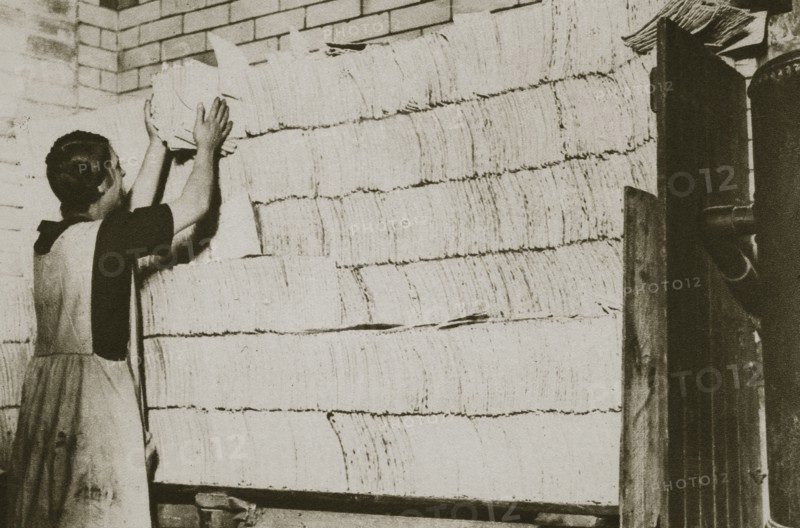 Stacking unleavened bread for the Passover in a Jewish bakery, 20th century. Artist: Unknown
