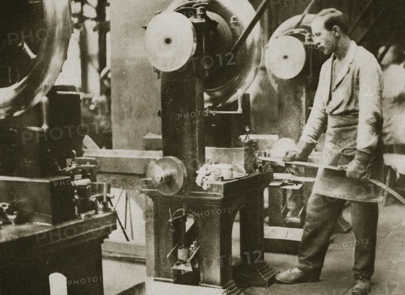 Money making; cutting strips of silver into disks, 20th century. Artist: Unknown