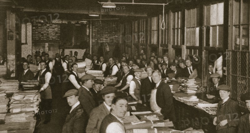 Newsvendors gather to pick up the next day's newspapers to sell, Carmelite House, 20th century. Artist: Unknown
