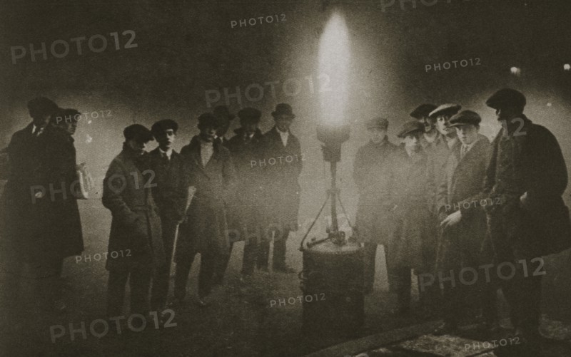 Gathering around an acetylene flare at a traffic control point in the fog, early 20th century. Artist: Unknown