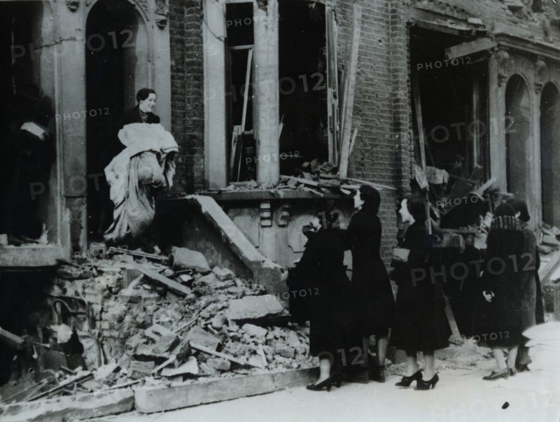 A woman collects her belongings from a bombed house, London, World War II, c1940-c1945. Artist: Unknown