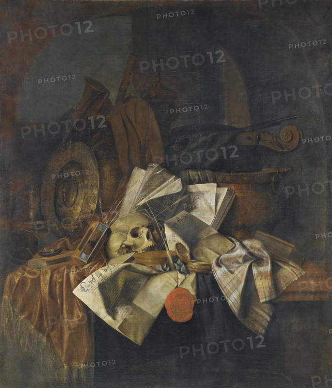 Vanitas still life with a skull, a shield, an hour glass, books and papers on a tabletop.