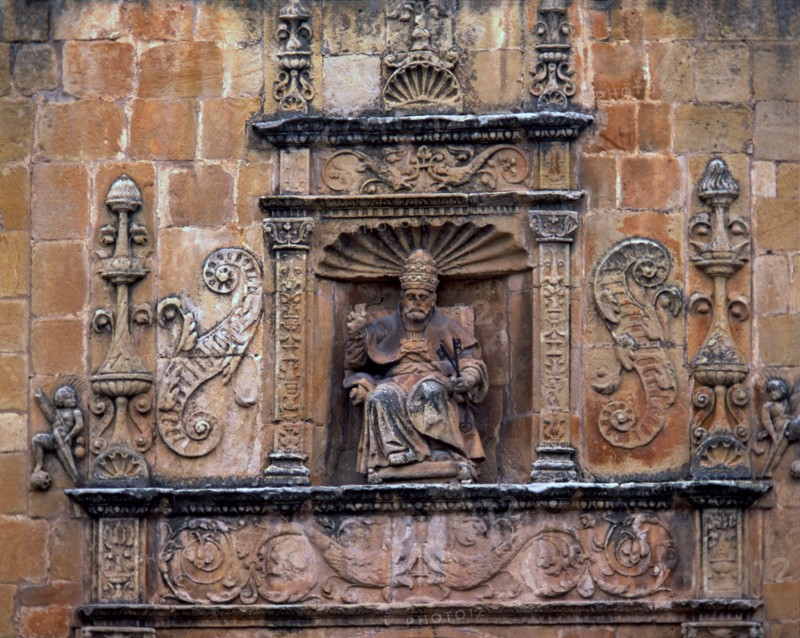 Front door of St. Peter's Cathedral, crowned by the seated image of Saint Peter Pope, embedded in?