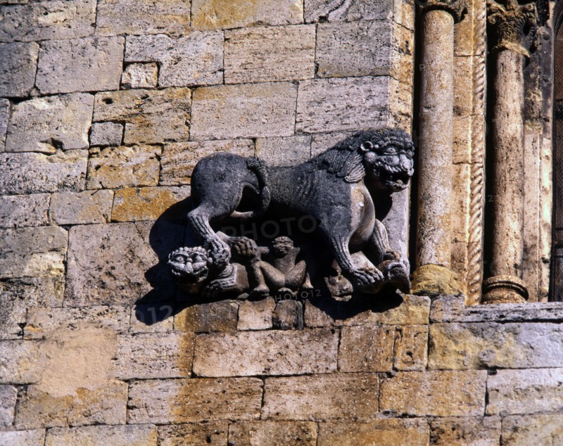 Church of San Pedro de Besalu, lion protecting a human figure and decorating the front window of ?