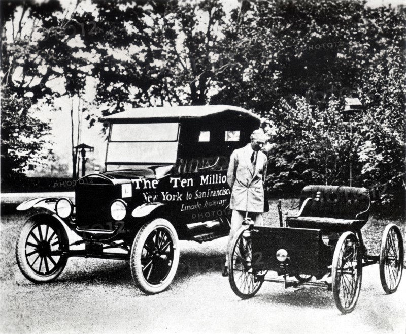 Henry Ford with old models of the Ford trademark.