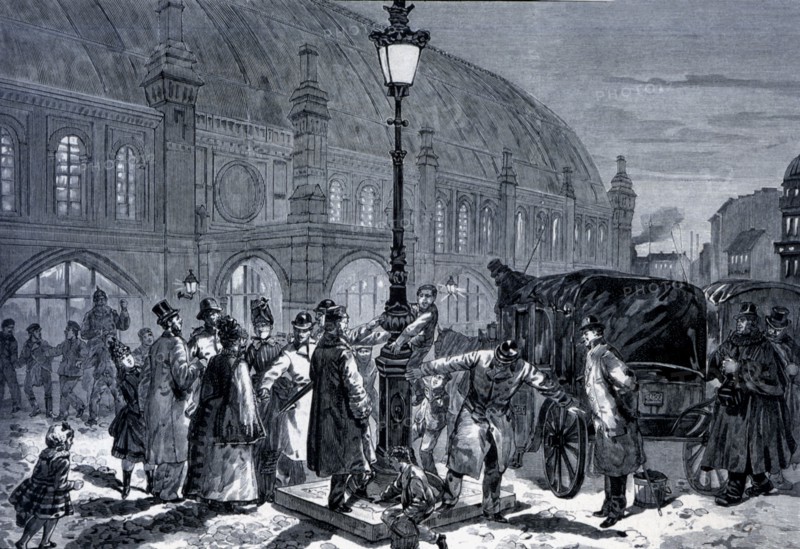 People around a new electrical lamppost in the train station of Friedrichstandt, engraving from 1?