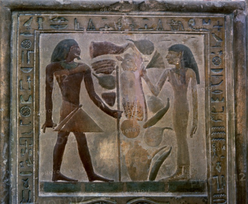 Door shaped stela representing Senouret and his wife in front of their offerings, made in polychr?