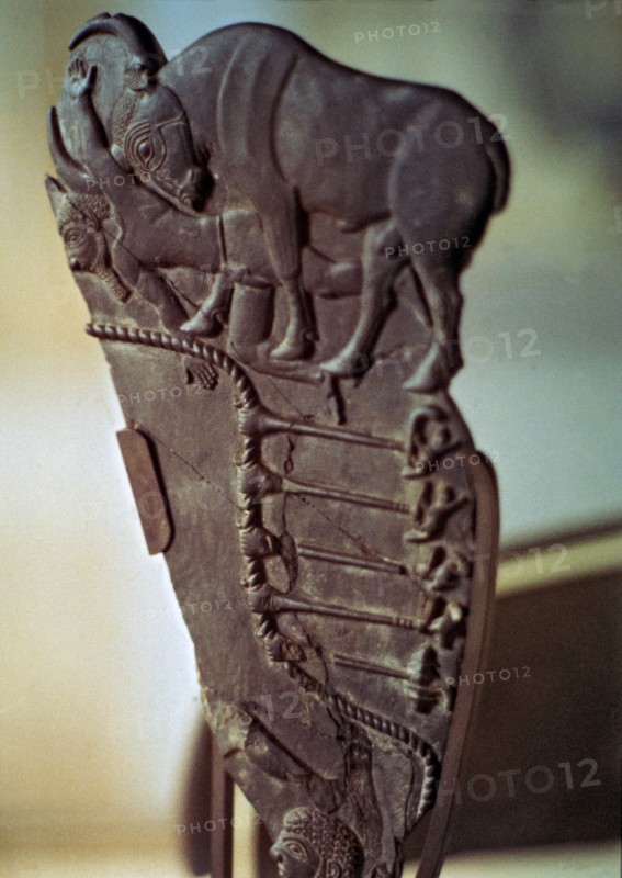 Fragment of an Egyptian palette with images of a bull fight. Made in schist.