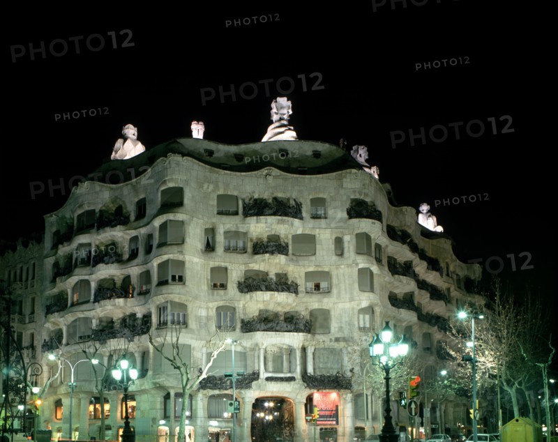 Façade of the Mila House or Pedrera lit at night, by Antoni Gaudí i Cornet (1852 - 1926).