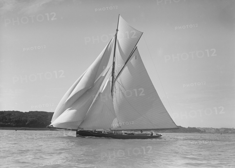 The gaff rigged cutter 'Bloodhound' sailing downwind under spinnaker, 1911. Creator: Kirk & Sons of Cowes.