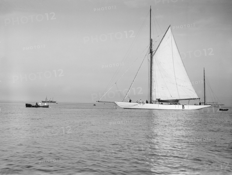 Sailing yacht 'Bona' being towed, 1912. Creator: Kirk & Sons of Cowes.