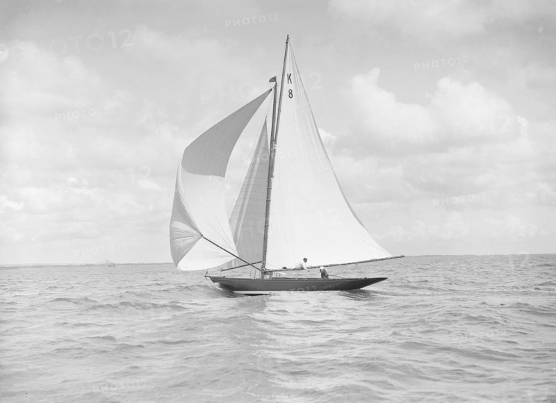 The 7 Metre yacht 'Pinaster' (K8) sailing with spinnaker, 1912. Creator: Kirk & Sons of Cowes.