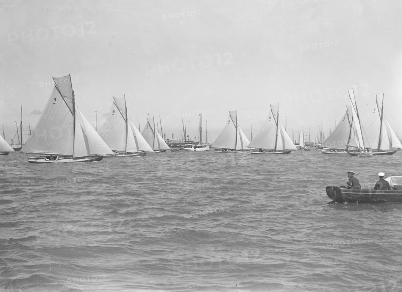Sailing yachts cross start line. Creator: Kirk & Sons of Cowes.