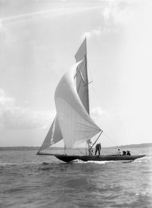 The 8 Metre 'Termagant' sailing with spinnaker, 1911. Creator: Kirk & Sons of Cowes.