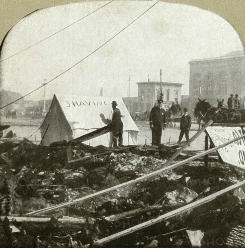 True grit - Barber painting sign on tent stretched on sidewalk of former place', 1906.
