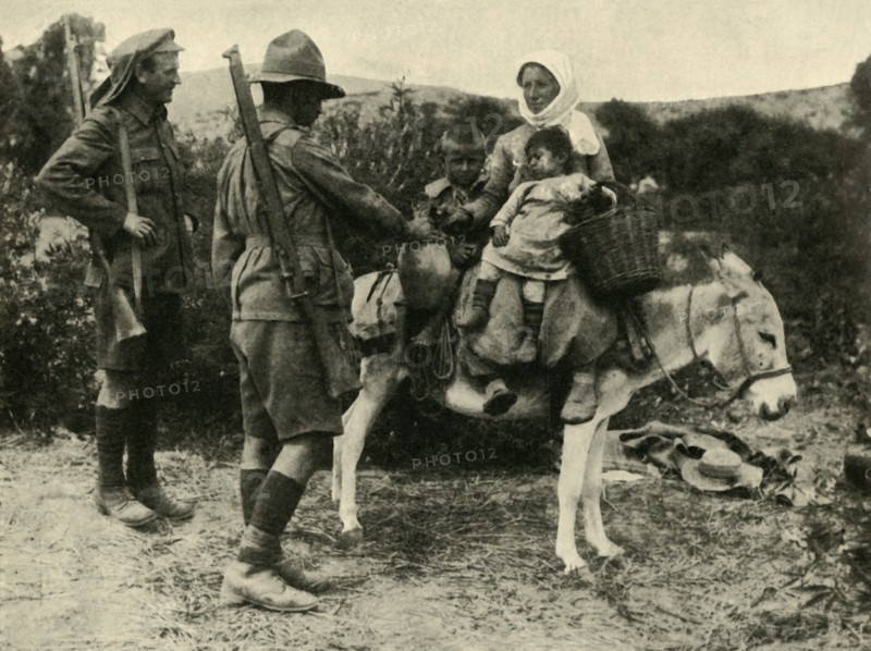 Australian soldier giving water to a Turkish family, First World War, 1915-1916, (c1920). Creator: Unknown.