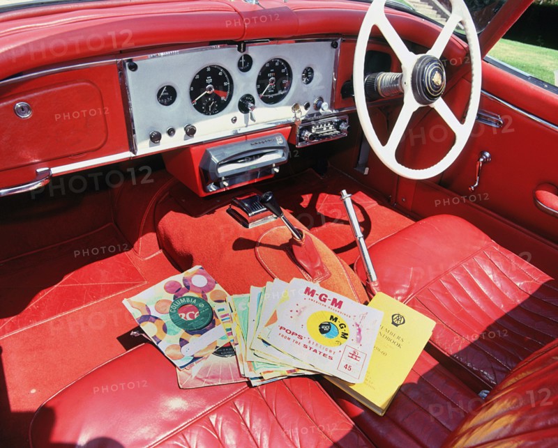 1960 Jaguar XK150 interior with record player and 7inch vinyl discs.. Creator: Unknown.