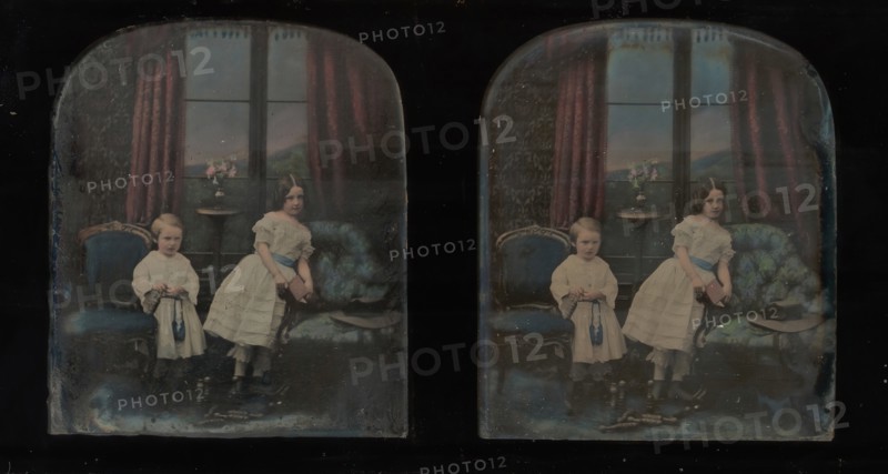 [Stereograph, Two Children Standing Between Furniture in a Studio Parlor Setting], ca. 1855.