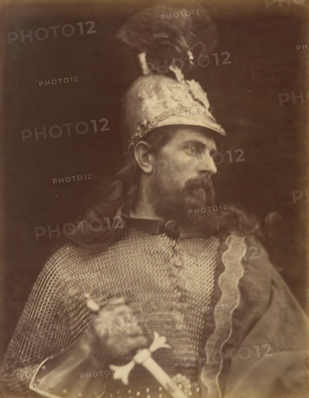 King Arthur, September 1874. A photograph of the torso and head in profile of a bearded and long-haired knight (William Warder) with helmet and chainmail gripping a sword. A photographic illustration to Alfred Tennyson's "Idylls of the King"; a series of narrative poems based on the legends of King Arthur.