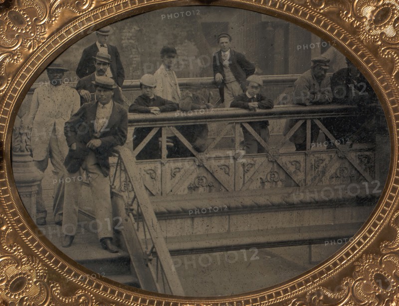 Group of Men and Boys Standing Along the Railing of the Fulton Street Bridge, 1866-68.