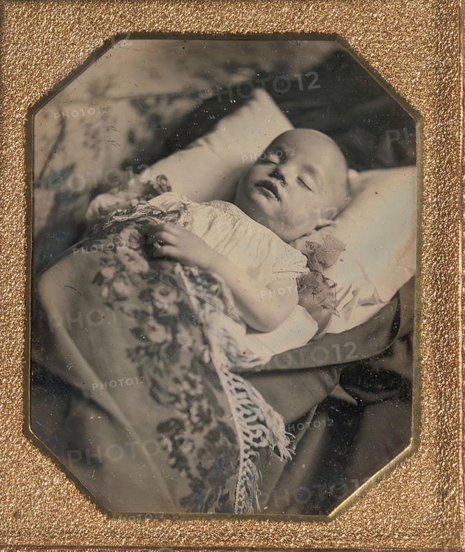 Postmortem Baby, Partially Covered by a Flowered Shawl with a Fringe Hem, 1840s.