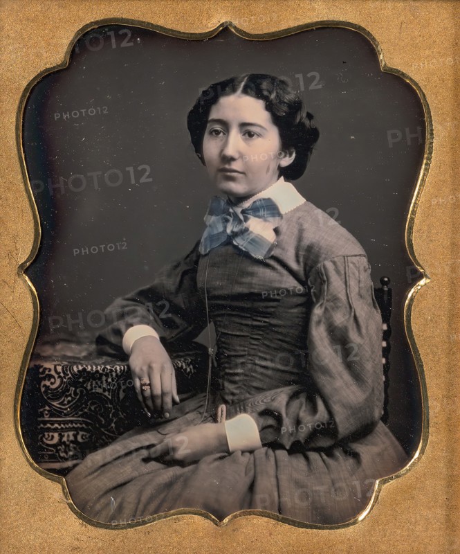 Seated Young Woman Wearing Collar with Large Bow, Resting Arm on Table, 1850s.
