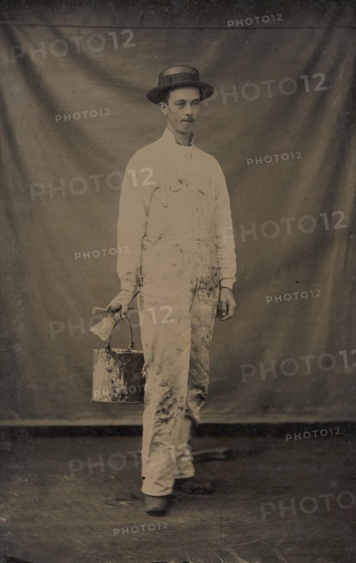 Painter in Paint-spattered Overalls with Brushes and Paint Can, 1870s-80s.