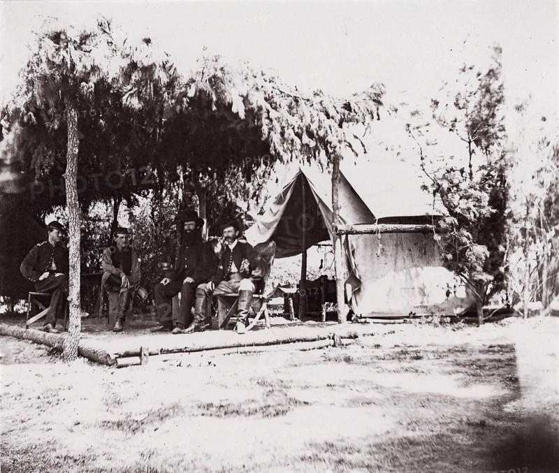 [Four men in camp under a lean-to of pine boughs], 1861-65. Formerly attributed to Mathew B. Brady.