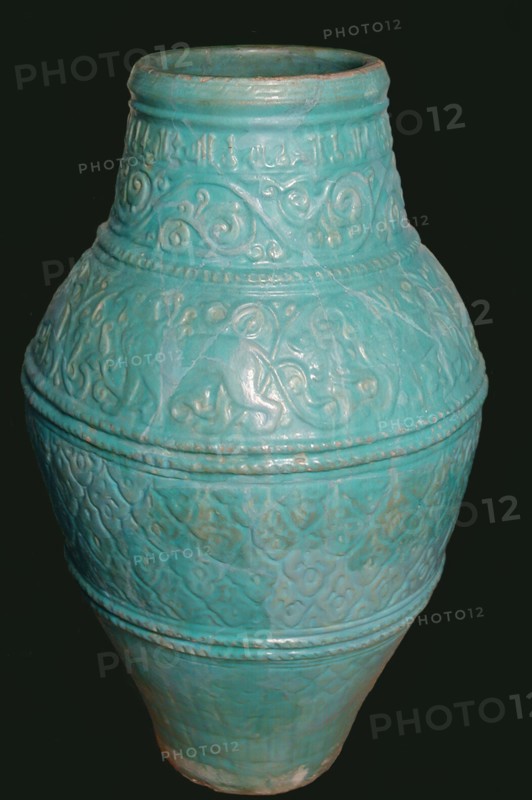 Large Turquoise Jar, Iran, 12th-13th century. Motifs typical of the Seljuq period including winged griffins and arabesque design. with inscriptions of good wishes  in small kufic script.
