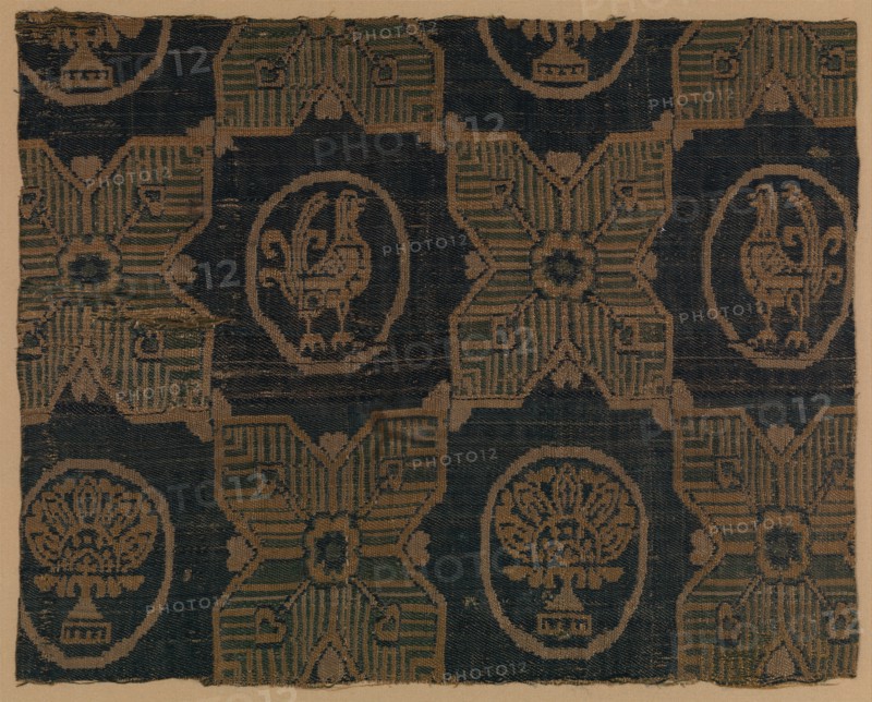 Textile Fragment, probably Iran, 8th-9th century. Four-pointed stars, in between  roundels bearing stylized florals and birds.