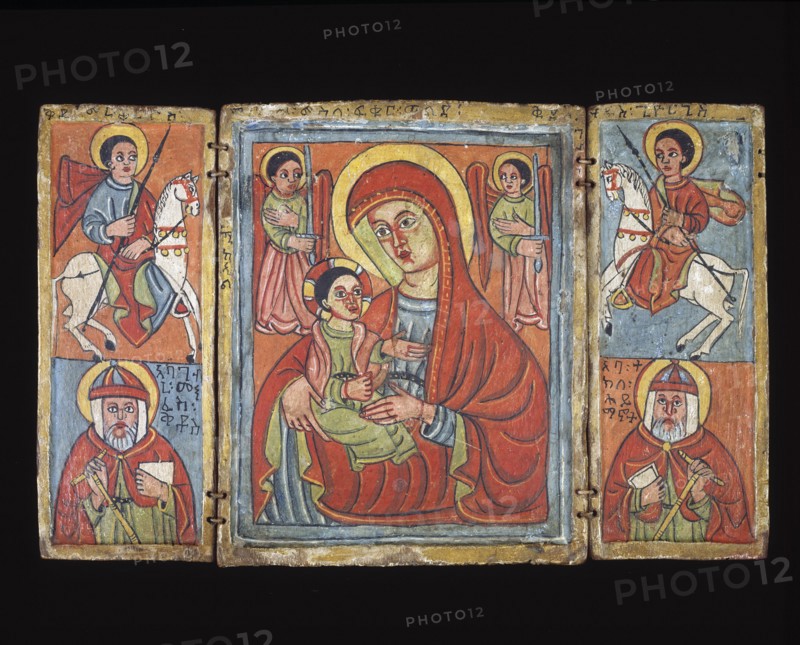 Icon, 16th century. Triptych of distemper and gesso on wood. Depicted in the left and right panels: Top register are equestrian Saints on white horses, bottom register, saint with red cloak, book, hand cross and conical hat. The central panel is Mary and Christ child flanked by archangels with swords. Mary has a red cloak/shawl and holds the child in her proper right arm.