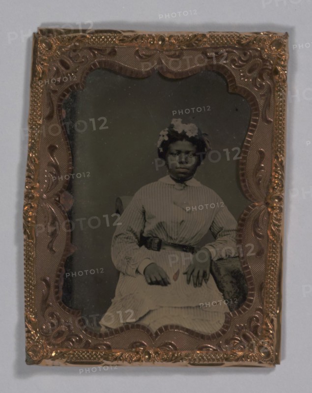 Tintype of a woman wearing a striped dress with flowers in her hair, 1855-1860s. Creator: Unknown.
